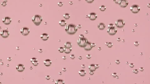 Macro shot of air bubbles in water rising up on light pink background. Slow Video stock 167431101
