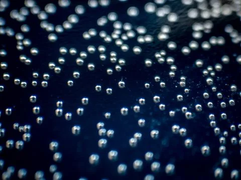 Macro shot of air bubles inside a water bottle on a blue background Stock Photos