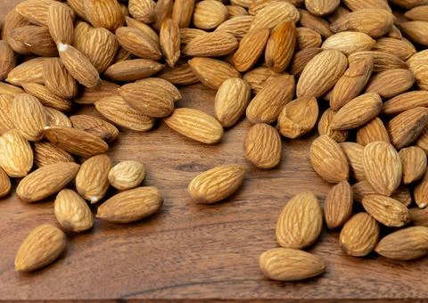 Macro shot of Almonds flat lay showcasing their texture on a wooden backgroun Stock Photos