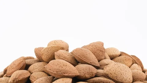 Macro shot of almonds isolated on white background, rotating (loopable) Vídeos de archivo 87702619