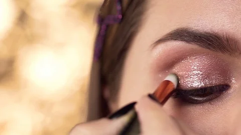Macro shot of applying makeup to the woman's eyelid, evening makeup, smokey eyes Stock Footage 99579349