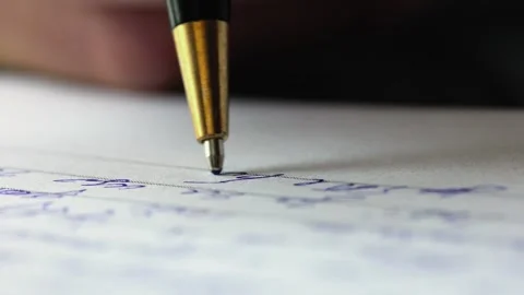 Macro shot of a ballpoint pen. A hand holds the pen and writes a letter or Stock Footage 251821634