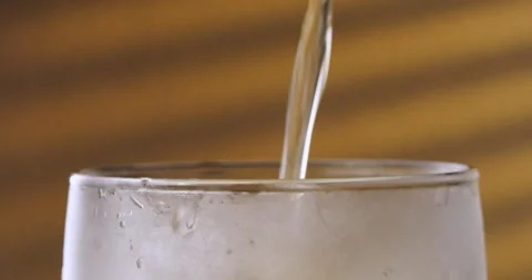 A macro shot of a beer glass into which a light beer is poured. Stock Footage 269764609