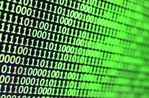 Macro shot of binary code on the monitor of an office computer. The concept o Stock Photos