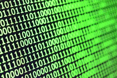 Macro shot of binary code on the monitor of an office computer. The concept o 스톡 사진