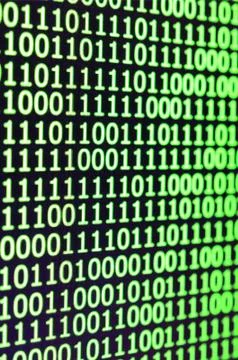 Macro shot of binary code on the monitor of an office computer. The concept o 库存照片