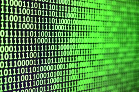 Macro shot of binary code on the monitor of an office computer. The concept o 库存照片