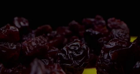 Macro shot in black key close-up of dry grapes of black raisins lying on a table Stock Footage 167855261