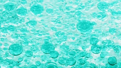 Macro shot of blue bubbles in water floating right with yellow background Video stock 124671097