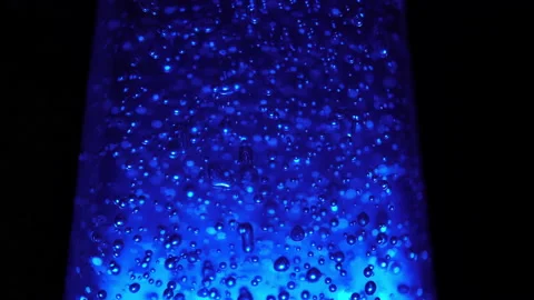 Macro shot of blurred bubbles on illuminating blue background Stock Footage 149525436