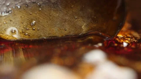 Macro shot of boiling caramelized sugar stirring with a spoon to make candy Stock Footage 144181793