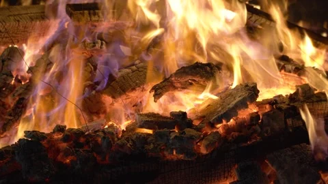 Macro shot bonfire made of logs in a brick firepit showing camping in the desert Stock Footage 277759886
