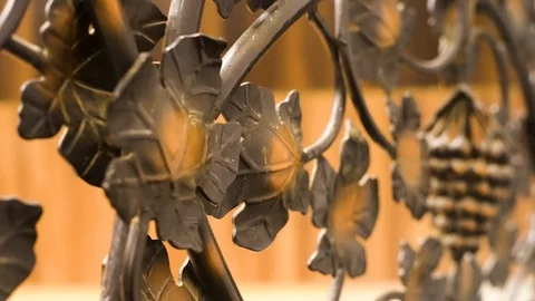 Macro shot of a brass cast iron railing with patterns of flowers and acorns in Stock Footage 125177829