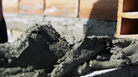 Macro Shot of Bricklayer Spreading Wet Cement Mortar with Masonry Trowel - 4K Stock Footage 340634754