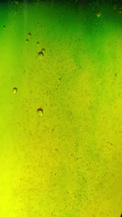 Macro shot of a bright green fluid with fine particles and air bubbles insid Stock Footage 340637656