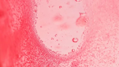 Macro shot of bright red water with many sparkling bubbles leaving a Video stock 124671178