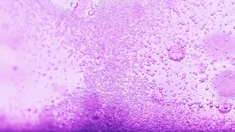Macro shot of bright violet water with many sparkling bubbles Video stock 124671074