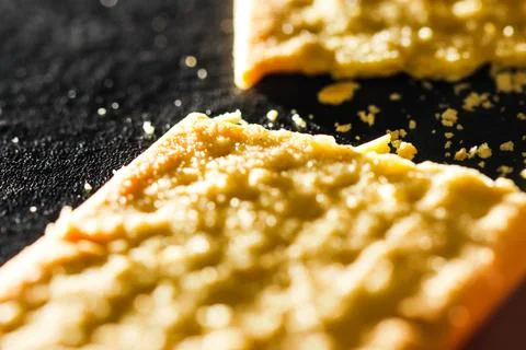 Macro Shot of Broken Vegetable Wheat Cracker with Scattered Crumbs on Black.. Stock Photos