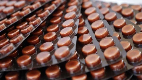 Macro shot of brown colored tablets. close rotating shot of brown colored pac Stock-Footage 147699485