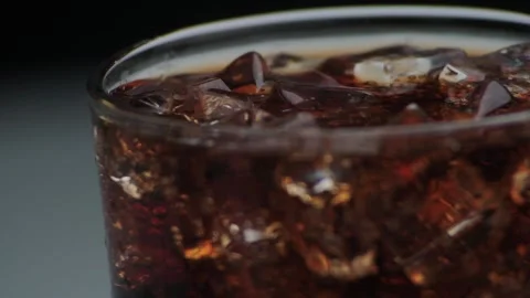 Macro shot of bubbles and ice in Cola, drops of water flowing down the glass Stock Footage 141822608
