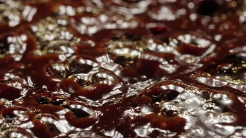 Macro shot of bubbles in boiling thick dark brown liquid, shallow depth of field Stock Footage 195292243