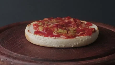 A macro shot of a bun covered with sauce and green salad  on a wooden board. Stock-Footage 140328053
