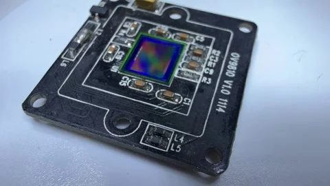 Macro shot of a camera module circuit board with an iridescent image sensor on Stock Footage 346799385