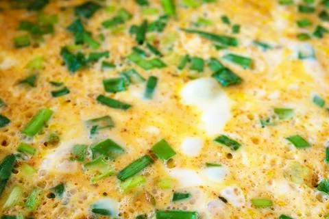 Macro shot capturing the texture of a homemade omelet cooked with fresh gre.. Stock Photos