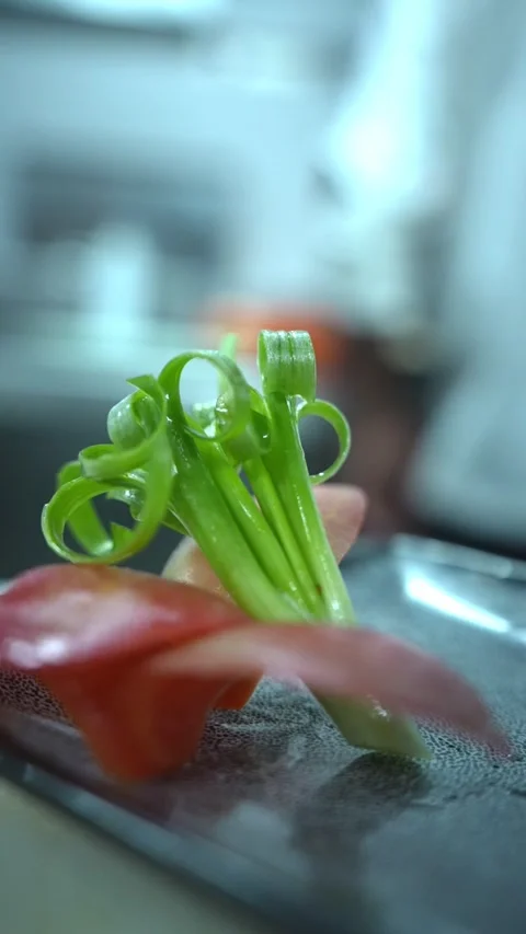 Macro Shot of Carved Spring Onion and Tomato Garnish on Platter 動画素材 348797470