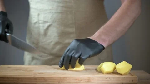 Macro shot of a chef in a white jacket carefully slicing fresh potatoes Stock Footage 166518047