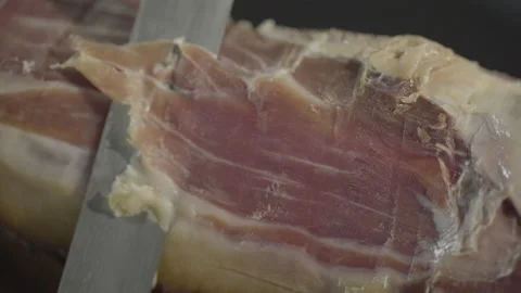Macro shot of chef's knife cutting ham, prosciutto Video stock 143649128