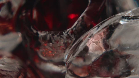 Macro shot of cherry drink beautifully pouring into glass with ice Stock Footage 114355321