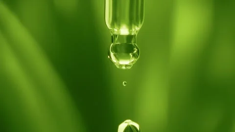 Macro shot of a clear plant extract or tea tree oil droplet falling Stock Footage 339280439