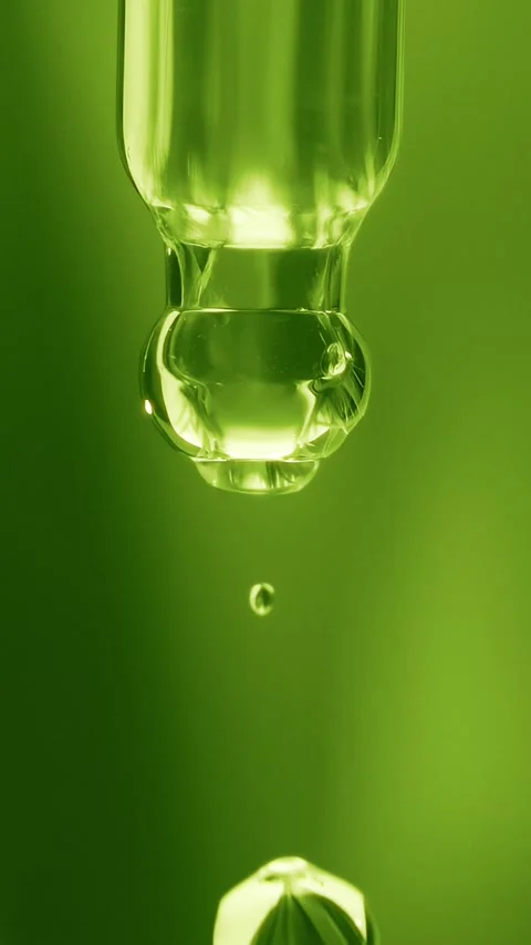Macro shot of a clear plant extract or tea tree oil droplet falling Stock Footage 339764574