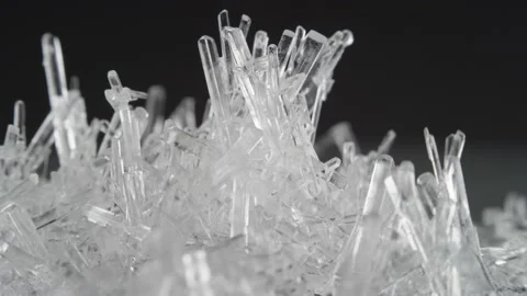 Macro shot of clear salt crystals rotate against black background and sparkle Stock Footage 156048026