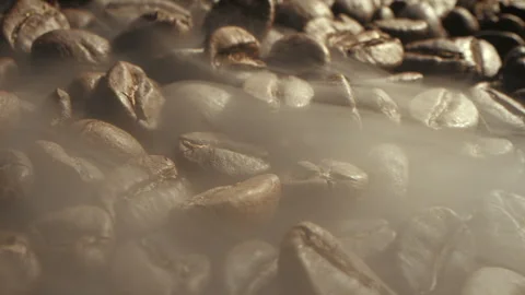 Macro shot of coffee bean roasting shot in the dark key of the smoke coming from Stock Footage 257838893