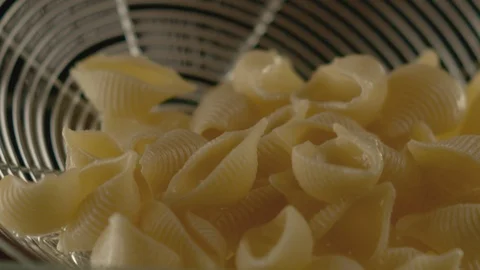 Macro shot of colander with prepared pasta pouring water. Slow motion video Stock Footage 116102127