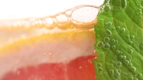 Macro shot of cold refreshing grapefruit lemonade with ice cubes and mint, .. Stock Footage 275885924
