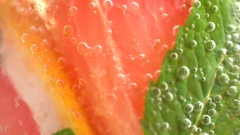 Macro shot of cold refreshing grapefruit lemonade with ice cubes and mint. Stock Footage 275886059