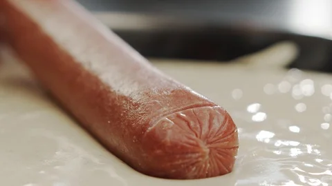 Macro shot cooking corn dog, dipping sausage into life dough in slow motion Stock Footage 117471361