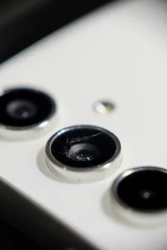 Macro shot of a cracked and broken smartphone camera lens Stock Photos