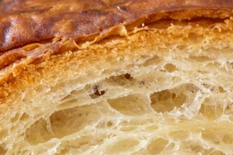 Macro shot of crispy golden bread crust and soft porous crumb. Stock Photos