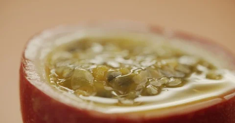 Macro shot of cut fresh passion fruit rotates on table. Slow motion video 4K Stock Footage 125020982