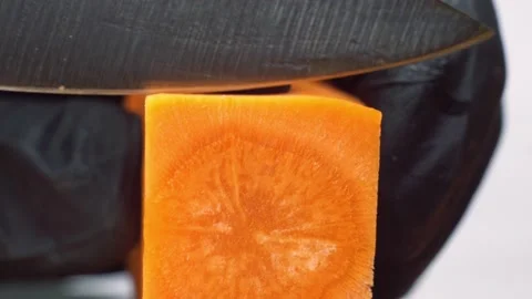 Macro shot of cutting square carrot with knife. Video stock 150772219