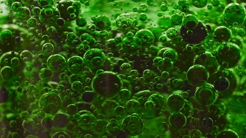 Macro shot of dark green bubbles getting mixed in water, slowly floating Video stock 124671168
