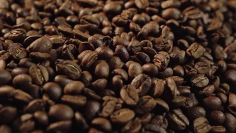 Macro shot of dark roasted coffee beans falling into a pile. 動画素材 336982977
