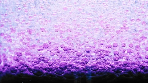 Macro shot of dark violet bubbles setting on ground of water with a bright Video stock 124671063