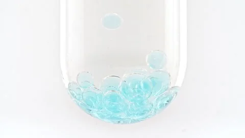Macro Shot of Different Sized Blue Bubbles in descending in Glass Test Tube on Stock Footage 274149026