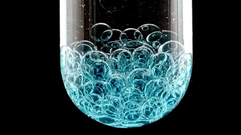 Macro Shot of Different Sized Blue Bubbles in descending in Glass Test Tube on Stock Footage 274150018