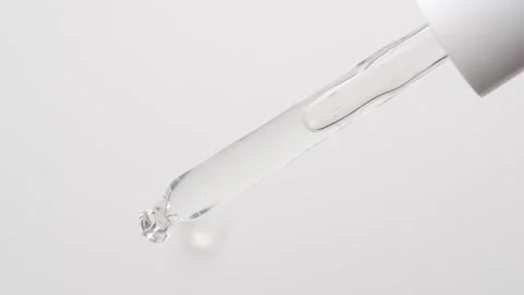 Macro shot of drop serum gel of is falling down from pipette on white backg.. Stock Footage 250528276